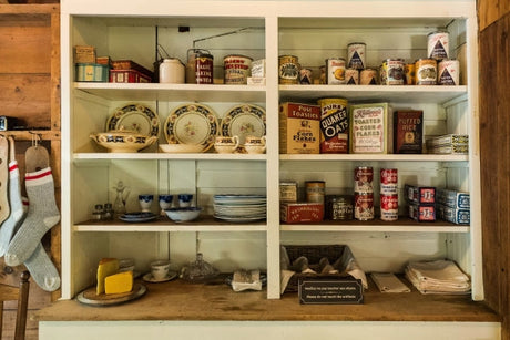 An open cupboard filled with dishes and spices