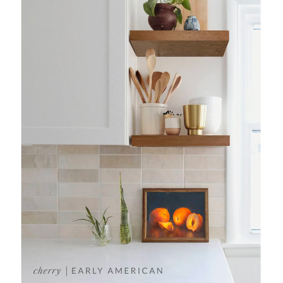 cherry floating shelves in a kitchen with the early American finish applied decorated with kitchen utensils, a plant, charcuterie board, and vases