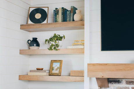 Beautiful wooden floating shelves against a white wall.