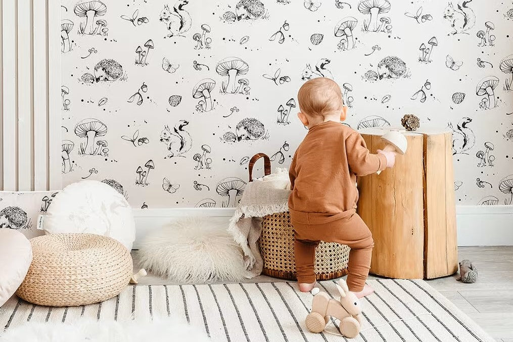 A child playing in a room with mushroom wallpaper
