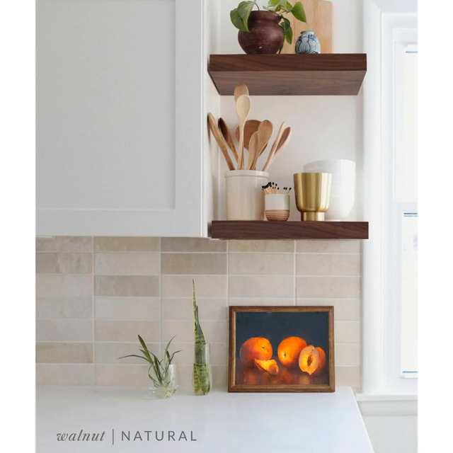 walnut floating shelves in a kitchen with the natural finish applied decorated with kitchen utensils, a plant, charcuterie board, and vases