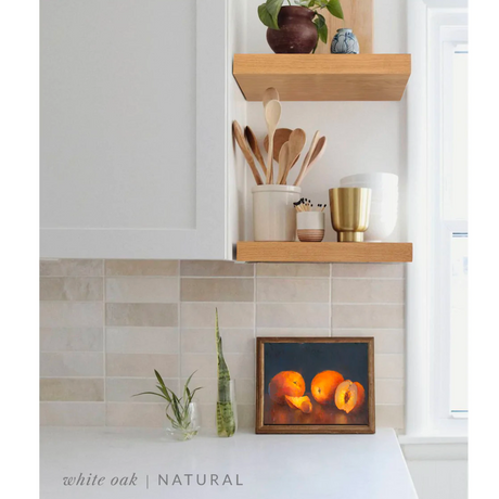 white oak floating shelves in a kitchen with the natural finish applied decorated with kitchen utensils, a plant, charcuterie board, and vases